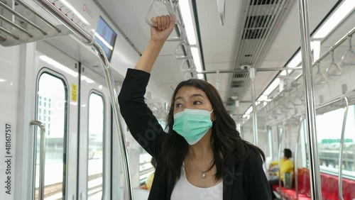 Passenger asian woman hands holding safety handle on the train in subway train