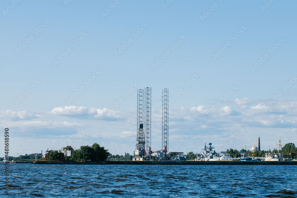 View from the water on the coastline of Kronstadt, cargo ships,Floating drilling rig, drilling cranes. Russia, Kronstadt,31.07.2021. View from the water on the coastline of Kronstadt, cargo ships,Floating drilling rig, drilling cranes. Russia, Kronstadt,31.07.2021.