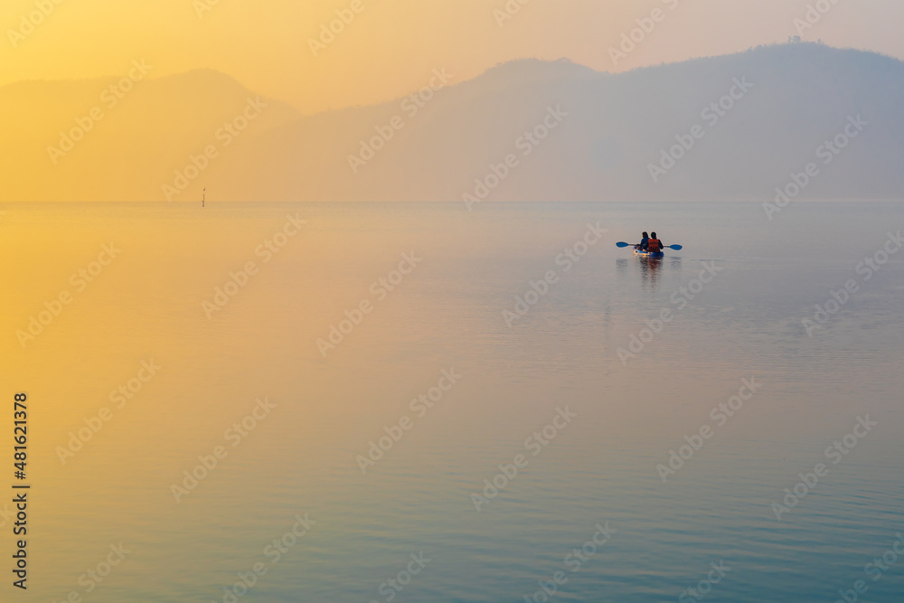 Sunrise time at lake or river with small kayak boat with mountain on the background. Sunrise time at lake or river with small kayak boat with mountain on the background.