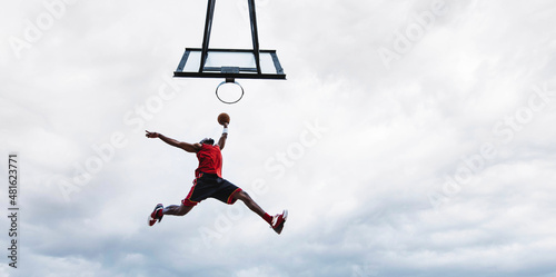Print op canvas Street basketball player making a powerful slam dunk on the court - Athletic mal