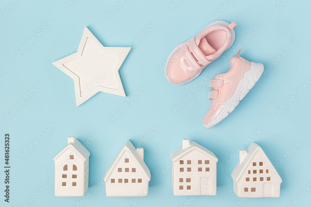 Pink sneakers and white ceramic houses on a blue background. Creative sport concept. Top view Flat lay