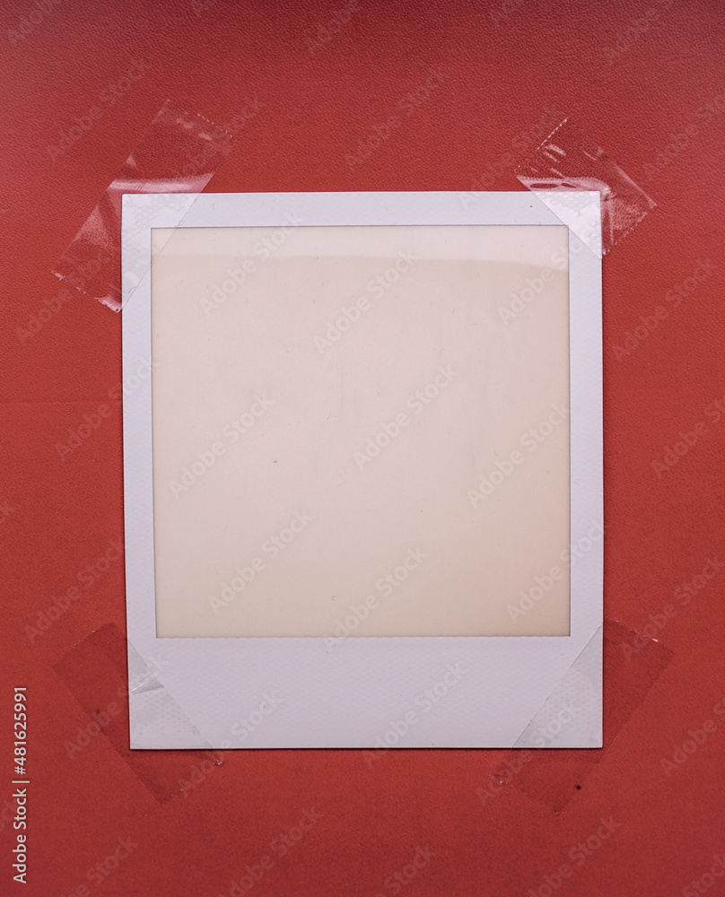 blank or empty instant film frame fixed by four sticker tape on red