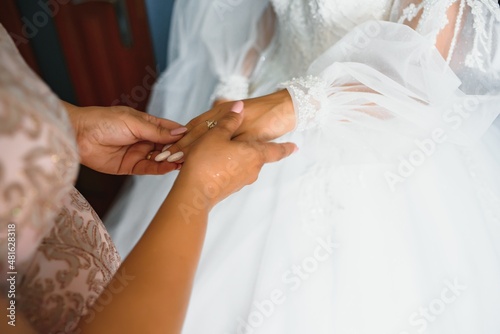 Close-up photo of a mother holding her daughter's hand on her wedding day. wedding concept. bridal morning