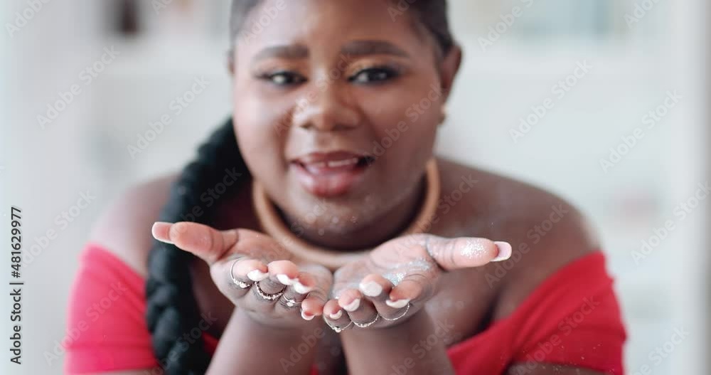 happy young woman in party outfit is blowing silver glitter dust out of her palms