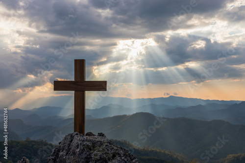 Fotografia Silhouettes of crucifix symbol on top mountain with bright sunbeam on the colorf