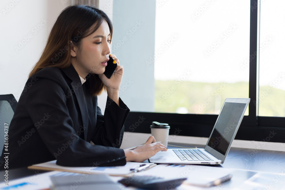 Businesswoman using the phone while working in the office. Businesswoman using the phone while working in the office.