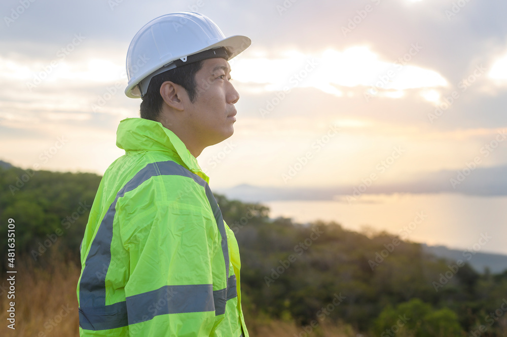 a man engineer is putting a protective helmet on her head at sunset.. a man engineer is putting a protective helmet on her head at sunset..