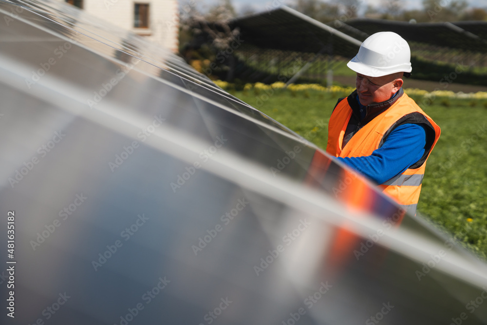 Man inspecting panels at a solar power plant Man inspecting panels at a solar power plant