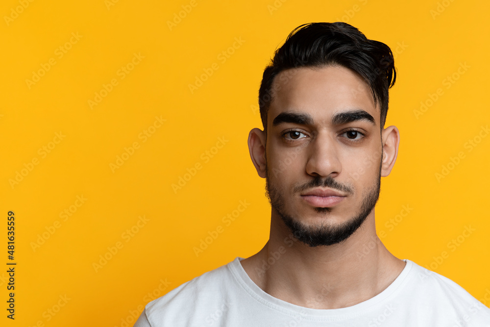 Obraz premium Attractive bearded arabic guy posing on yellow