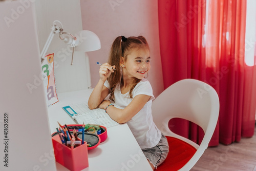 a first grader is doing her hometask in her room	
  photo