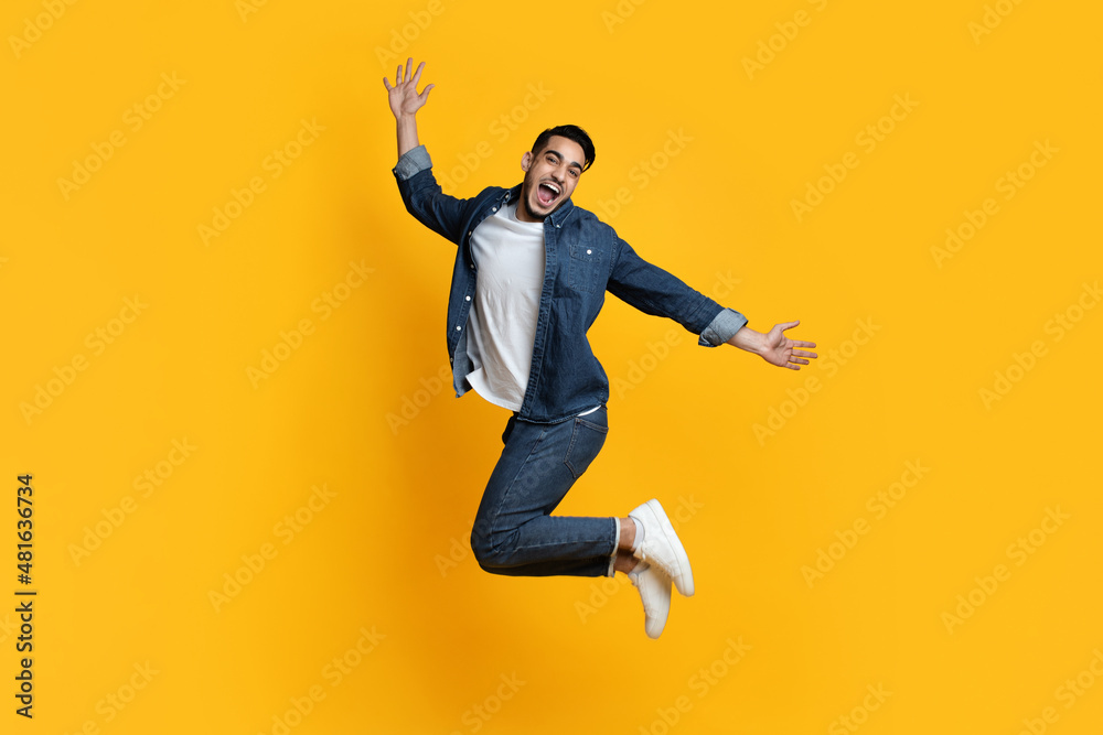 Emotional middle-eastern guy posing on yellow, full length