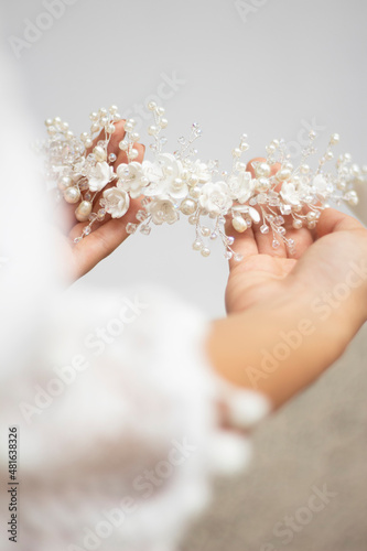 Φωτογραφία bride hands hold wedding hair accesory with white flowers