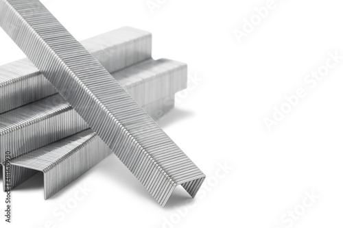 Stack of staples for stapler gun isolated on white background, close up, copy space. Industrial tool. photo