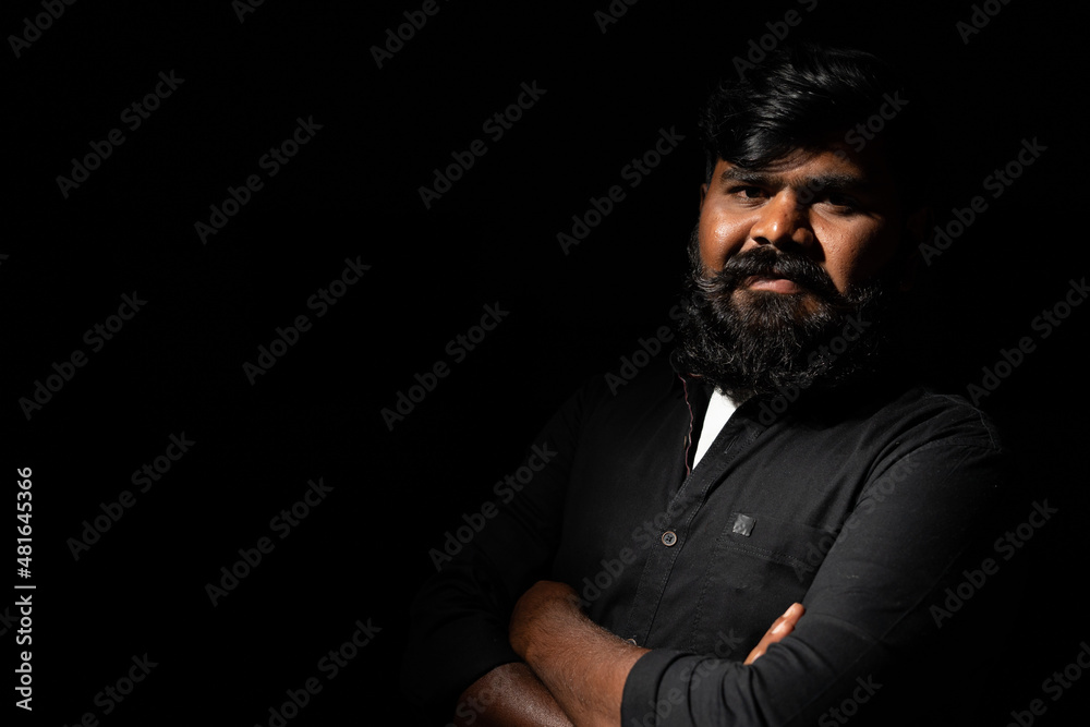 Young indain beardman with crossed arms standing against dark background - Conncept of self confident, positive emotion and happiness Young indain beardman with crossed arms standing against dark background - Conncept of self confident, positive emotion and happiness
