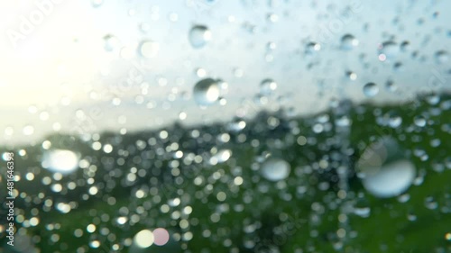 Flying through water drops sprinkles floating in pure clean evening air in super slow motion with countryside on the background