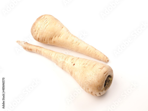 Two organic parsnips on a white studio background