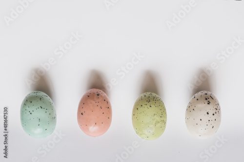 Four colored speckled eggs on white background