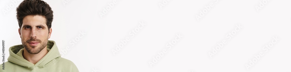 Obraz premium Pleased handsome man in sportswear posing and looking at camera