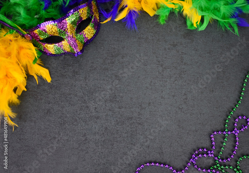 Mardi Gras Carnival Mask, Feather Boa and Beads Over Blackboard Background