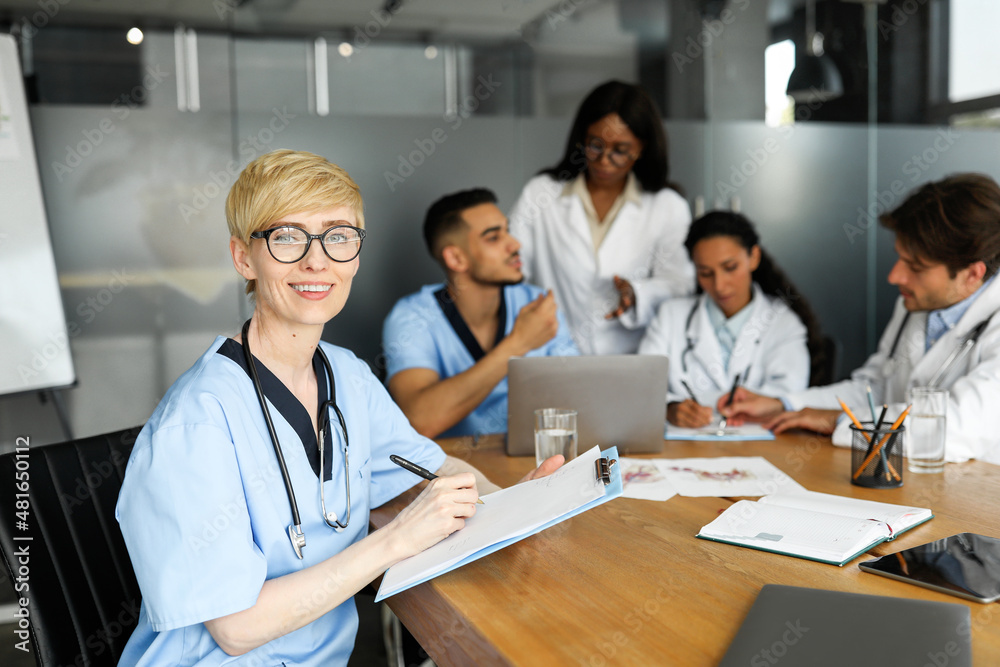 Portrait of young blonde woman doctor having brainstorming with colleagues
