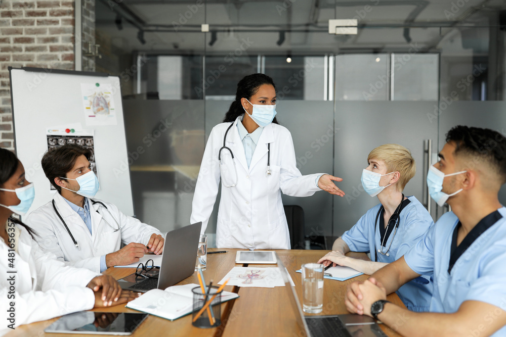 International team of doctors in face masks having medical conference International team of doctors in face masks having medical conference