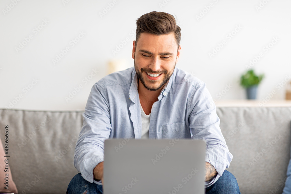 Recruitment concept. Happy millennial guy browsing work opportunities online, using job search website on laptop