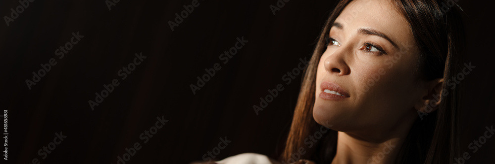 Smiling middle aged woman holding cup while sitting indoors Smiling middle aged woman holding cup while sitting indoors