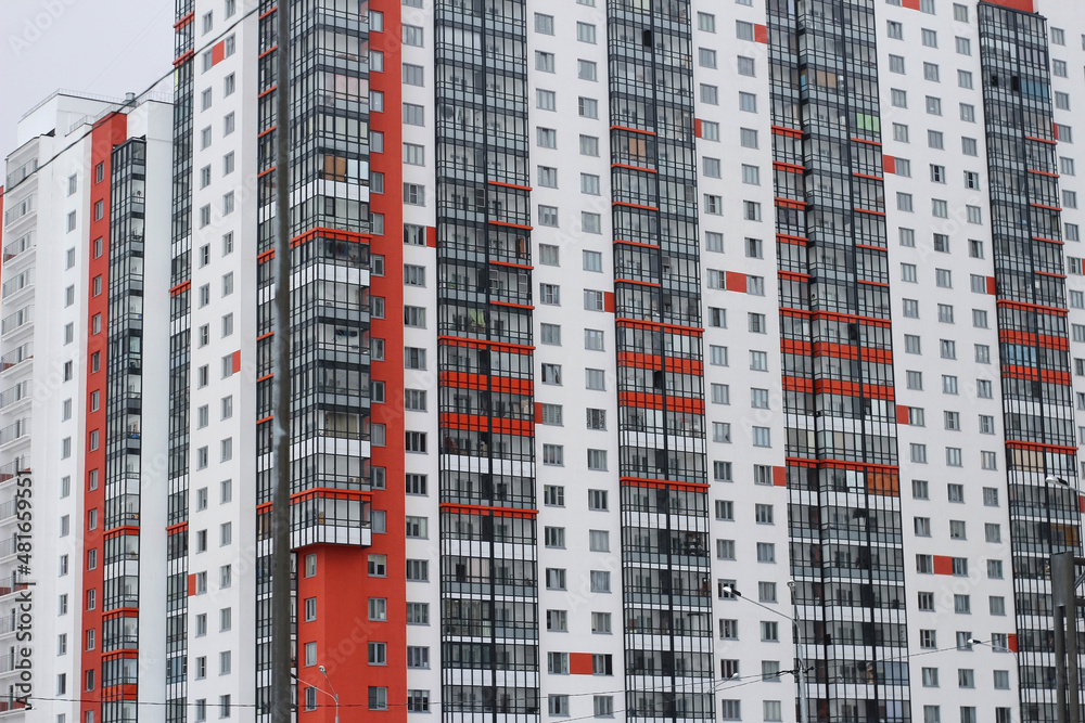 Residential red and white high-rise building with glass balconies Residential red and white high-rise building with glass balconies