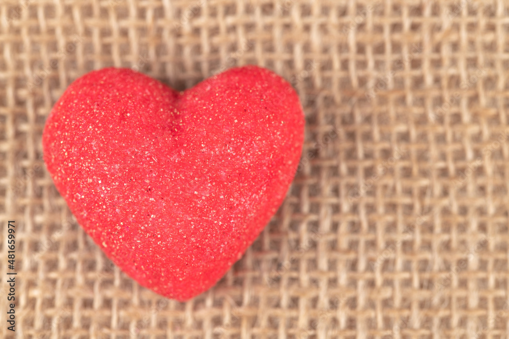 Red heart shape marshmallow in a sackcloth background Red heart shape marshmallow in a sackcloth background