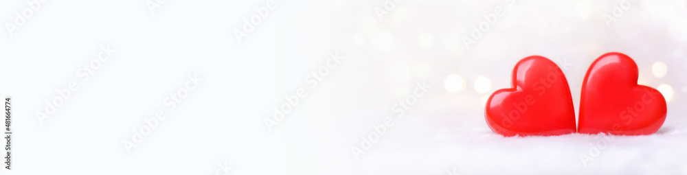 Fototapeta premium Two red hearts on a white background with bokeh. Postcard for Valentine's Day.Banner.Happy Valentine's Day.Copy space