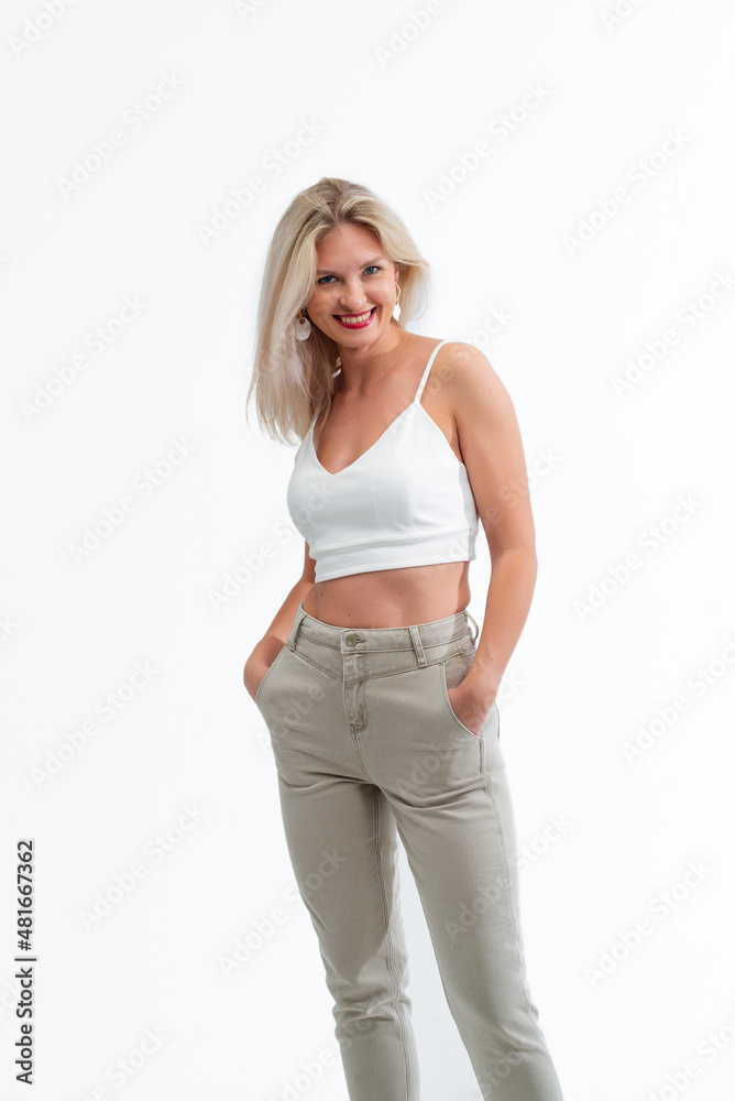 Beautiful blonde in jeans in the studio on a light background. Beautiful blonde in jeans in the studio on a light background.