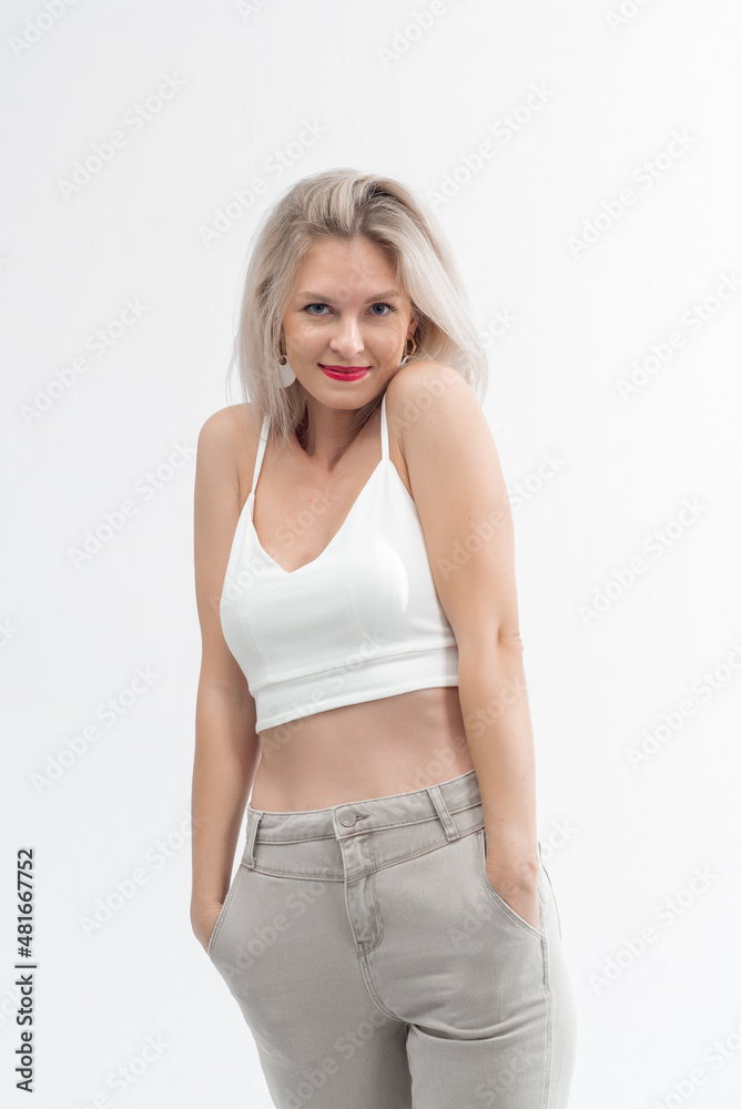 Beautiful blonde in jeans in the studio on a light background. Beautiful blonde in jeans in the studio on a light background.