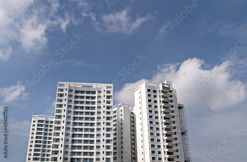 Image of tall buildings under construction with blue sky background in Pune  Maharashtra.