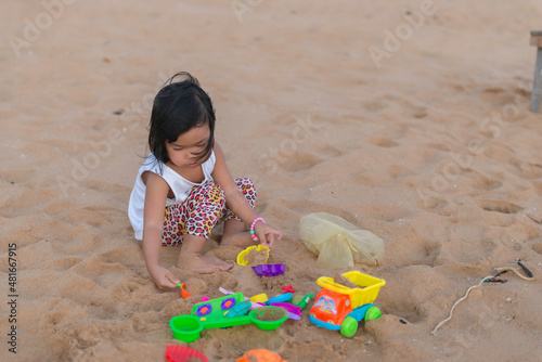 A little girl play sand at side sea beach on the sunset,Thailane people,Relax time © reewungjunerr