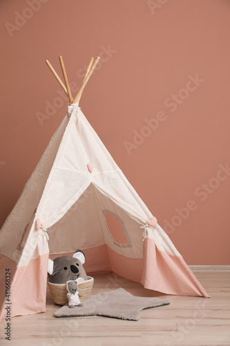 Cute child room interior with play tent near pink wall © New Africa