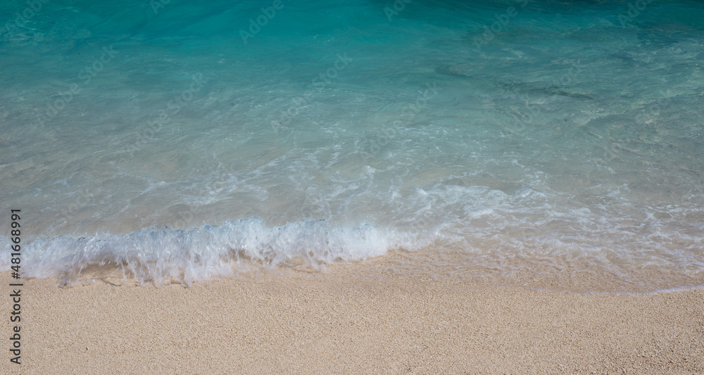 Soft wave of the sea on the sand beach. Beach sand background.