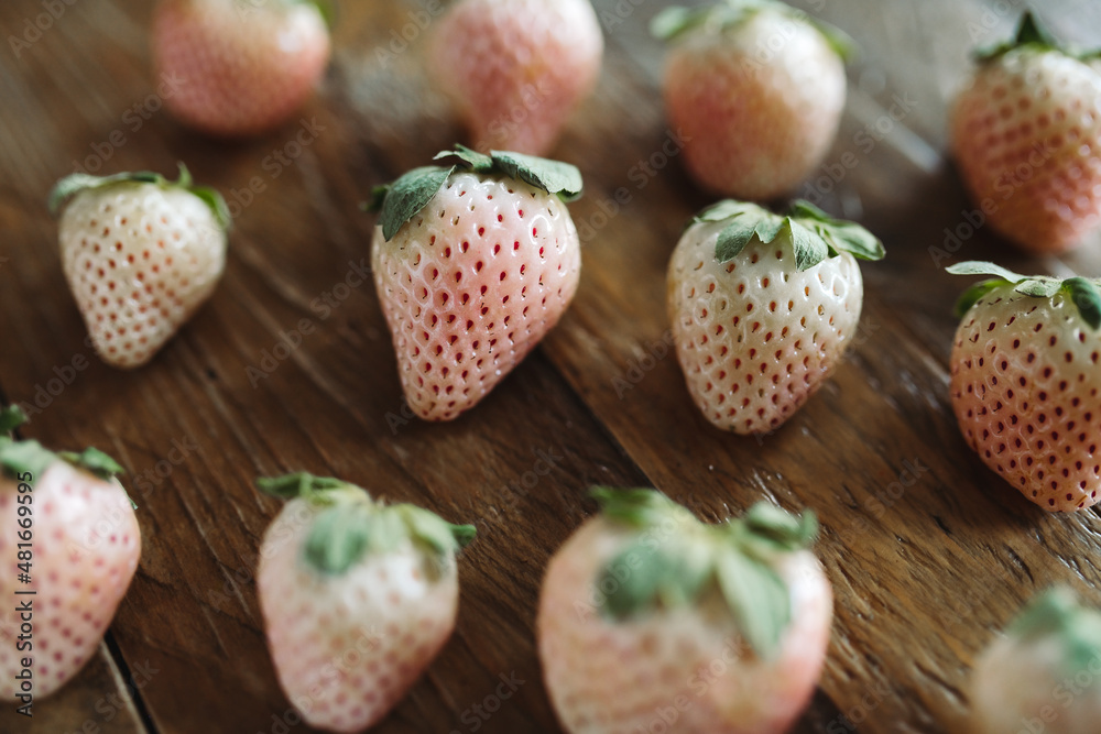 Fresh Fruit Flat Lay. Close Up Pineberries on Wooden Table. White Strawberries. Seasonal Fruit Still Life. Pink and White Berries on Dark Background. Fresh Fruit Flat Lay. Close Up Pineberries on Wooden Table. White Strawberries. Seasonal Fruit Still Life. Pink and White Berries on Dark Background.