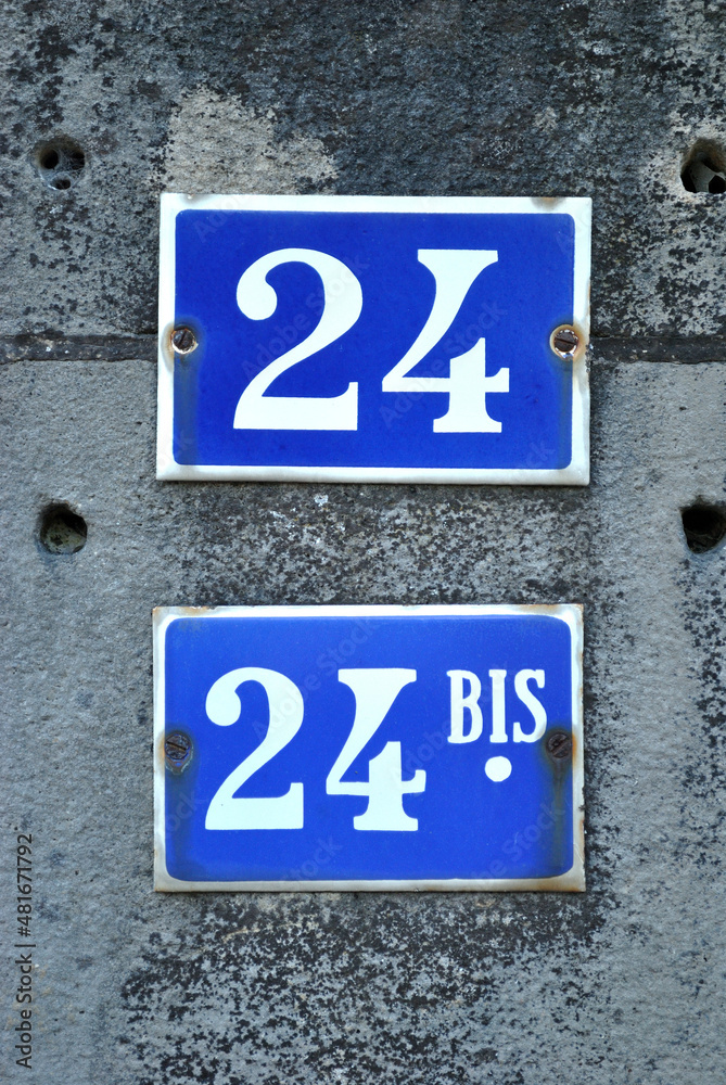 Close Up of Blue Enamel Numbers '24 and 24bis' on Building Close Up of Blue Enamel Numbers '24 and 24bis' on Building