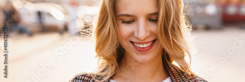 Smiling young blonde woman using mobile phone