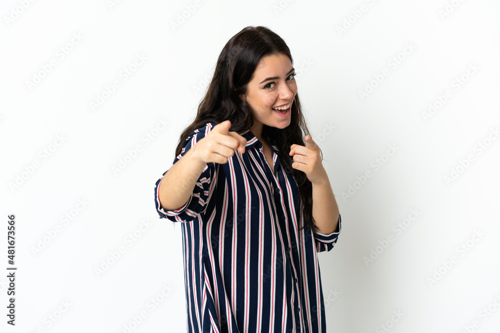 Young caucasian woman over isolated background surprised and pointing front Young caucasian woman over isolated background surprised and pointing front
