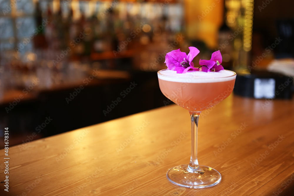 Pink cocktail with flowers on the table. Pink cocktail with flowers on the table.