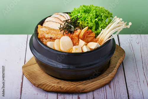 Korean food Ramen Kimchi Jjigae with grilled pork belly and ramen in black metal bowl on wooden background photo