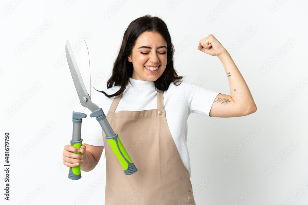Young caucasian woman holding a plant isolated on white background doing strong gesture Young caucasian woman holding a plant isolated on white background doing strong gesture
