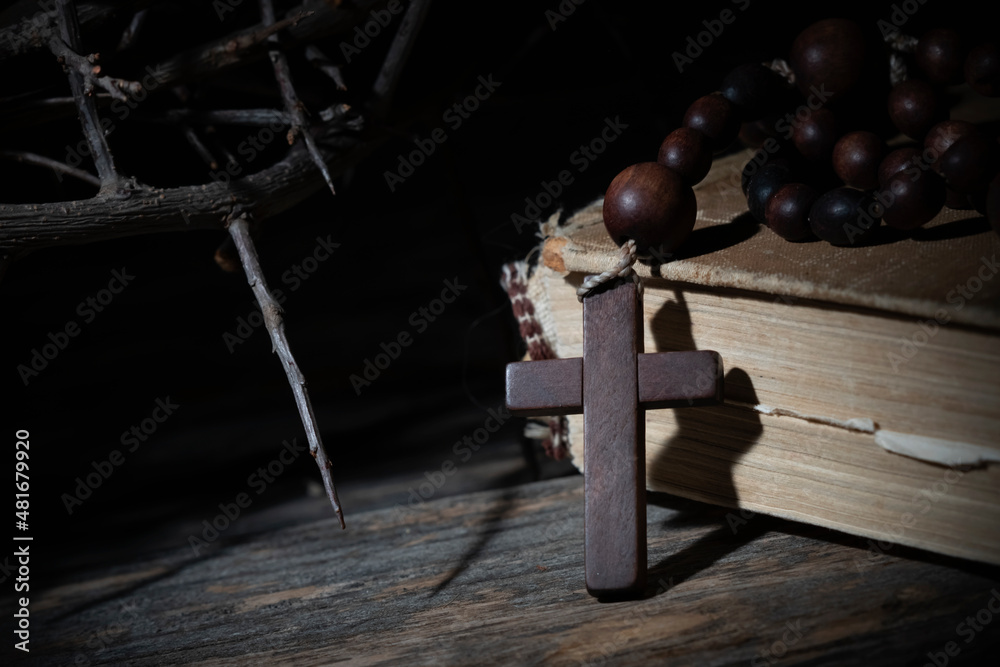 Close up rosary, ancient Bible and thorn wreath as symbol of death and resurrection of Jesus Christ.