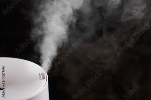 Modern air humidifier on black background photo