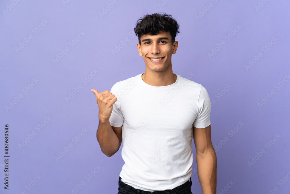 Young Argentinian man isolated on background pointing to the side to present a product Young Argentinian man isolated on background pointing to the side to present a product