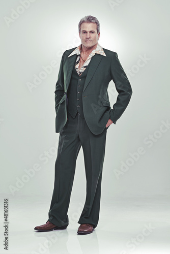 He's a show biz bigshot. Full length studio portrait of a mature man in a retro suit striking a confident pose.