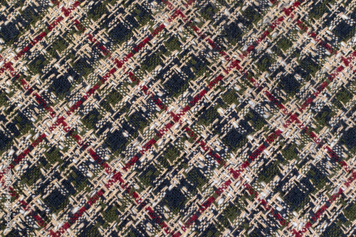 Green checkered fabric with colored threads. Scottish wool. Fabric for a plaid coat and suit. Close-up. Background