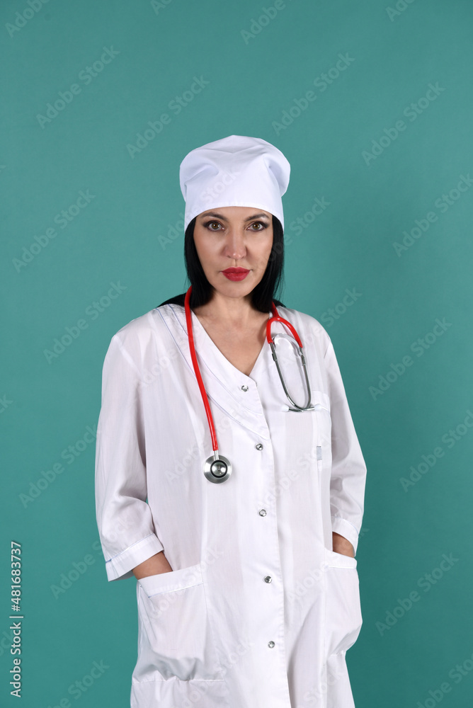 A female therapist in a white coat and a white headdress on a green background with a stethoscope A female therapist in a white coat and a white headdress on a green background with a stethoscope