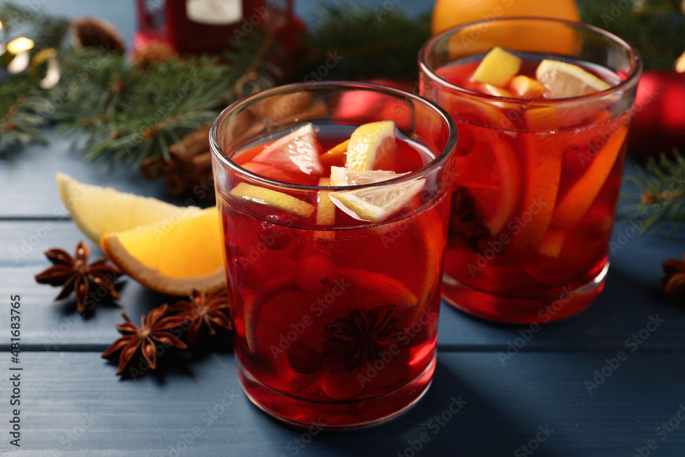 Delicious punch drink with cranberries and orange on blue wooden table Delicious punch drink with cranberries and orange on blue wooden table